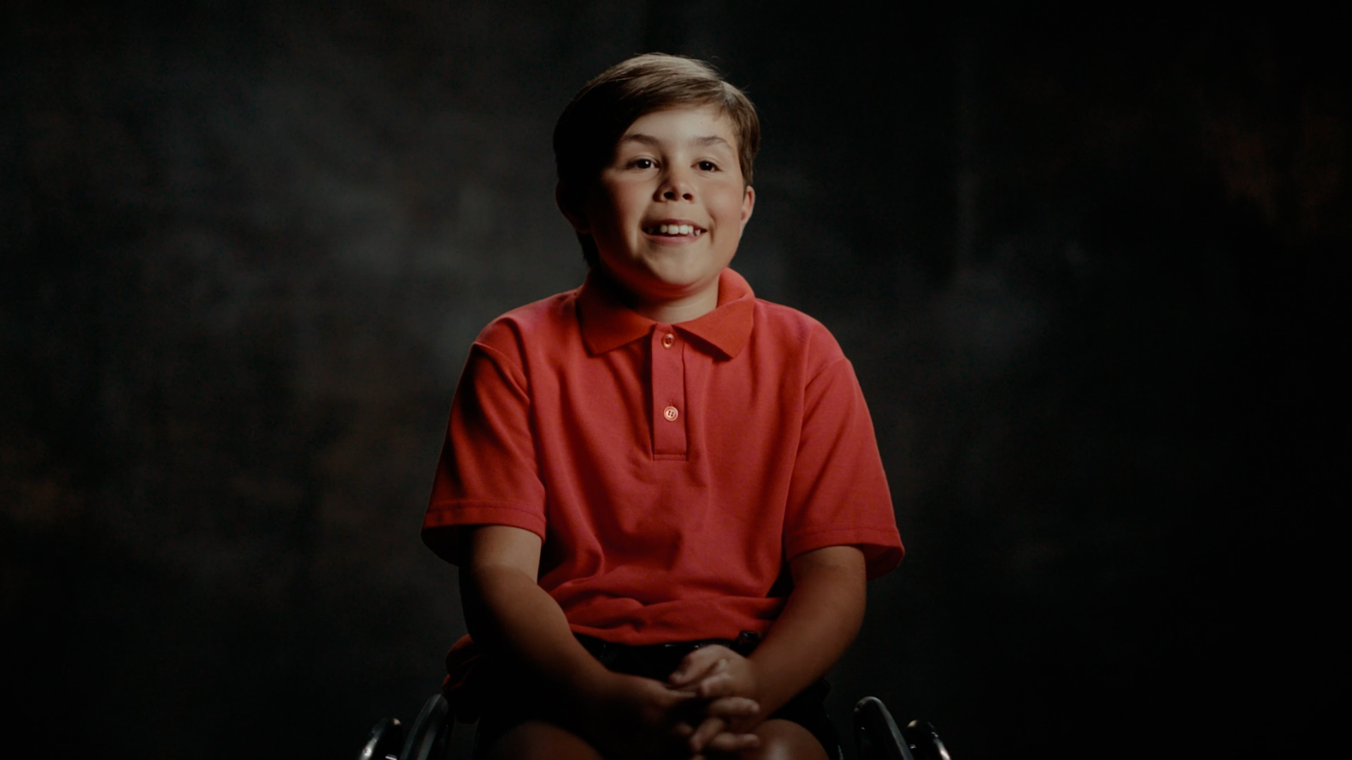 Portrait of young boy in red shirt smiling